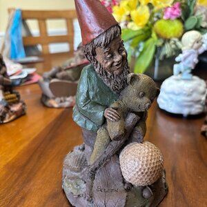 Tom Clark Golden Gnome-  Gnome holding Teddy Bear looking at Golf Ball